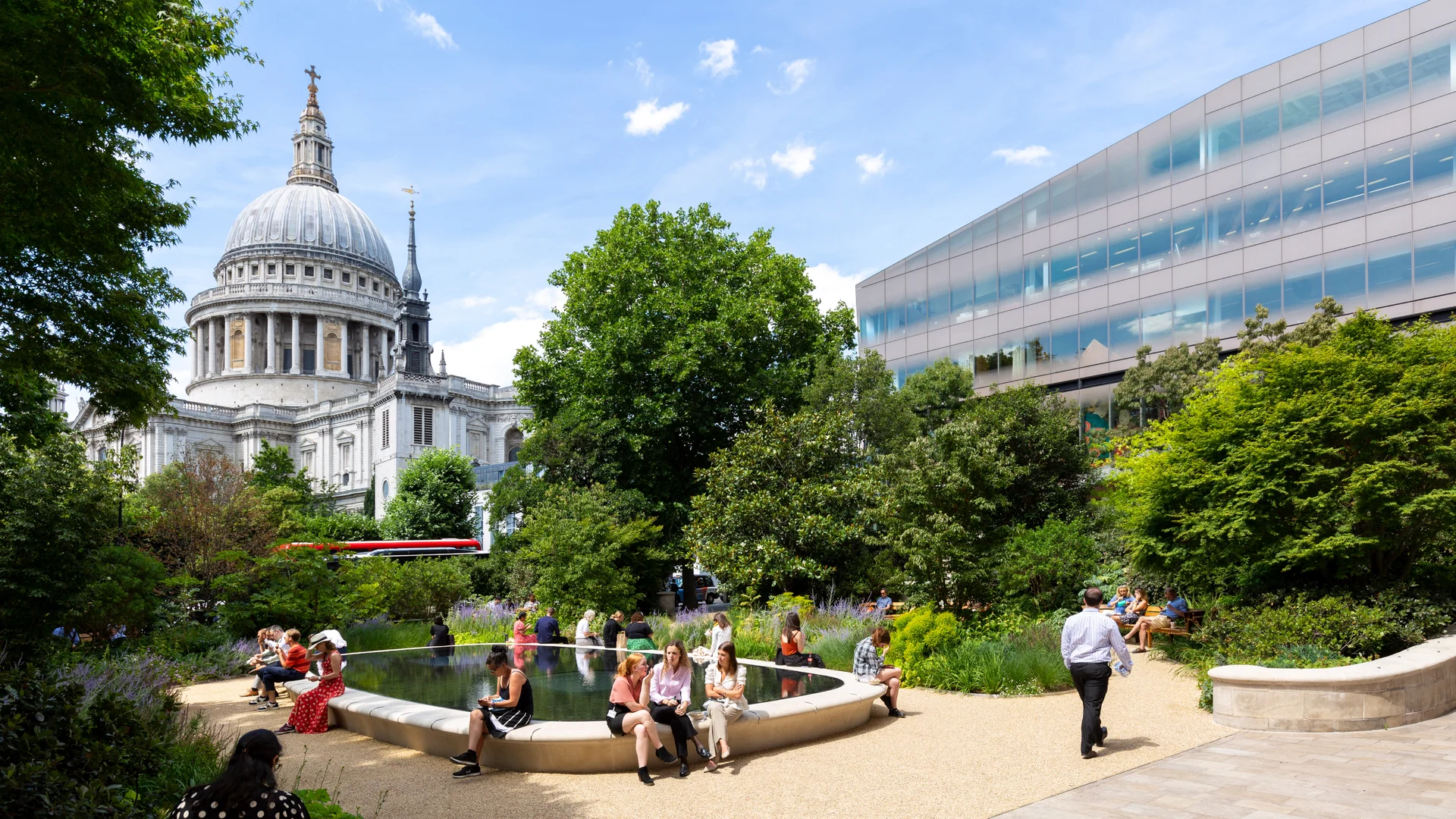 People relaxing and sitting by the pond in garden near St Paul's Cathedral