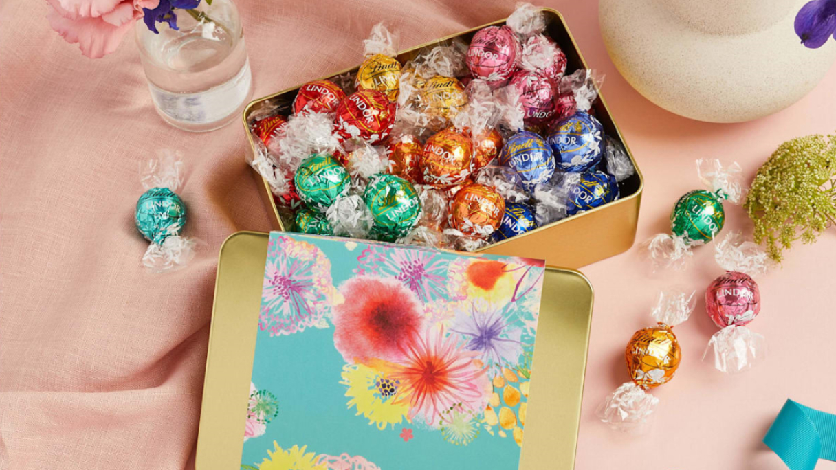 Box of Lindt chocolates on table with flowers