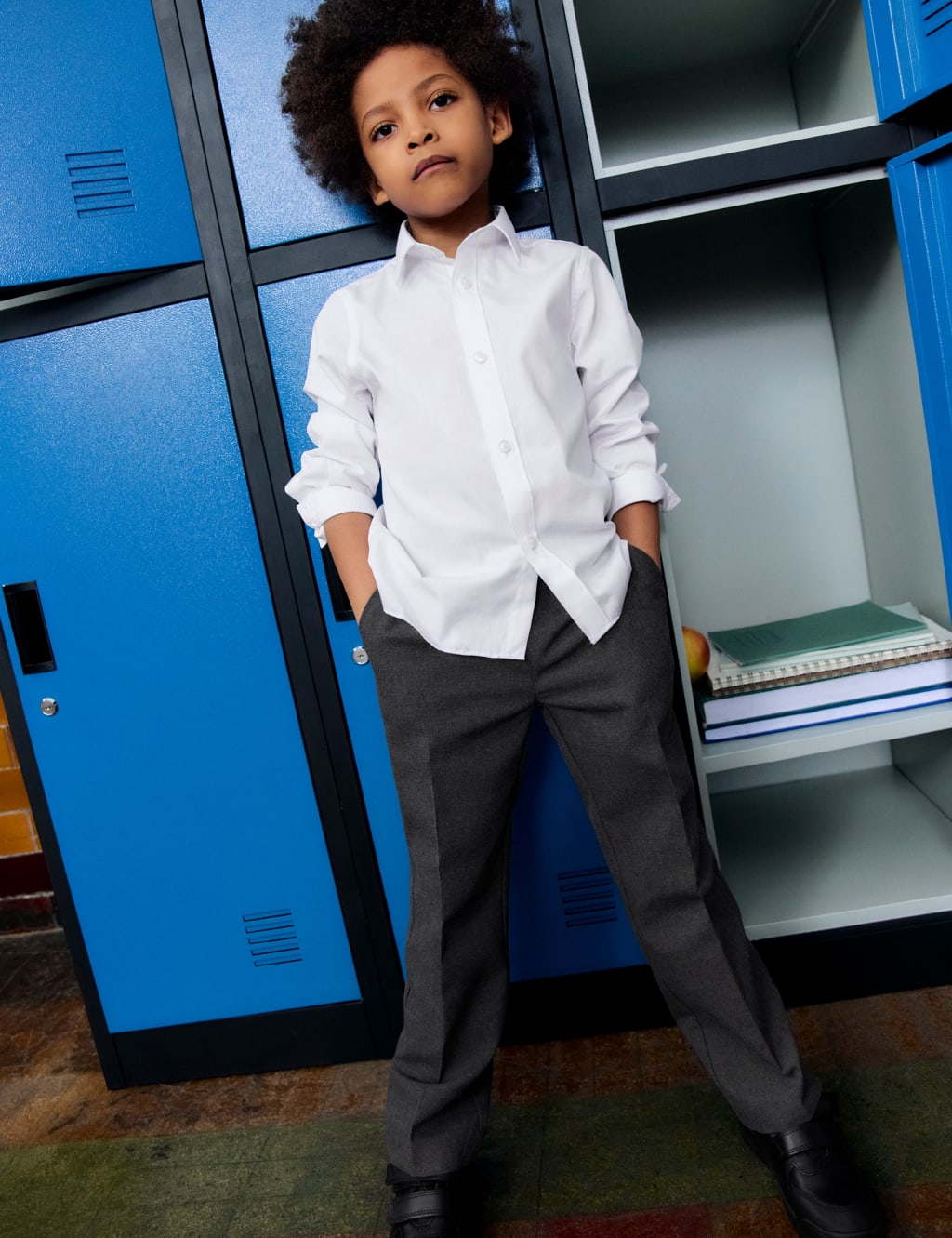 A school child standing in front of lockers