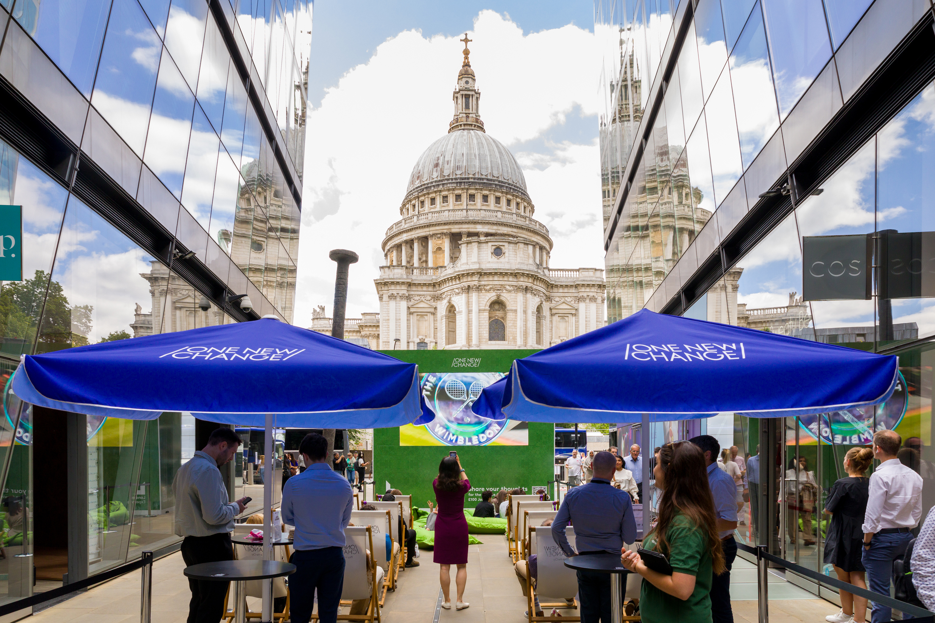 View of St Pauls from the passage showing the big screen and people under large blue umbrellas