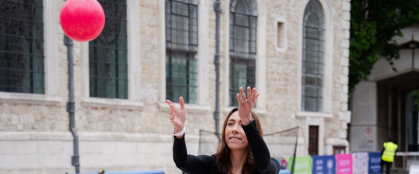 A woman throwing a pink ball