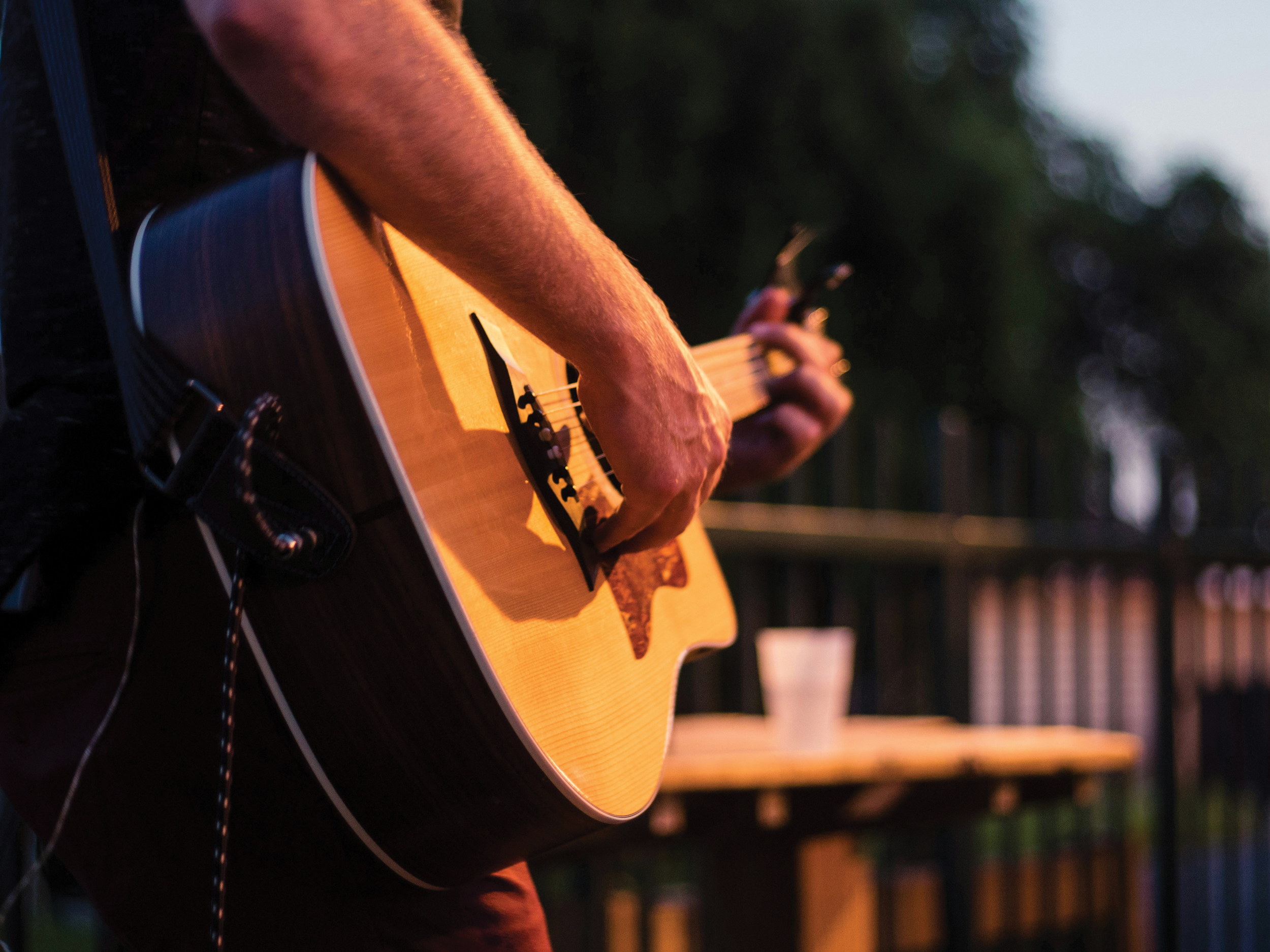 A close up of a man playing a guitar