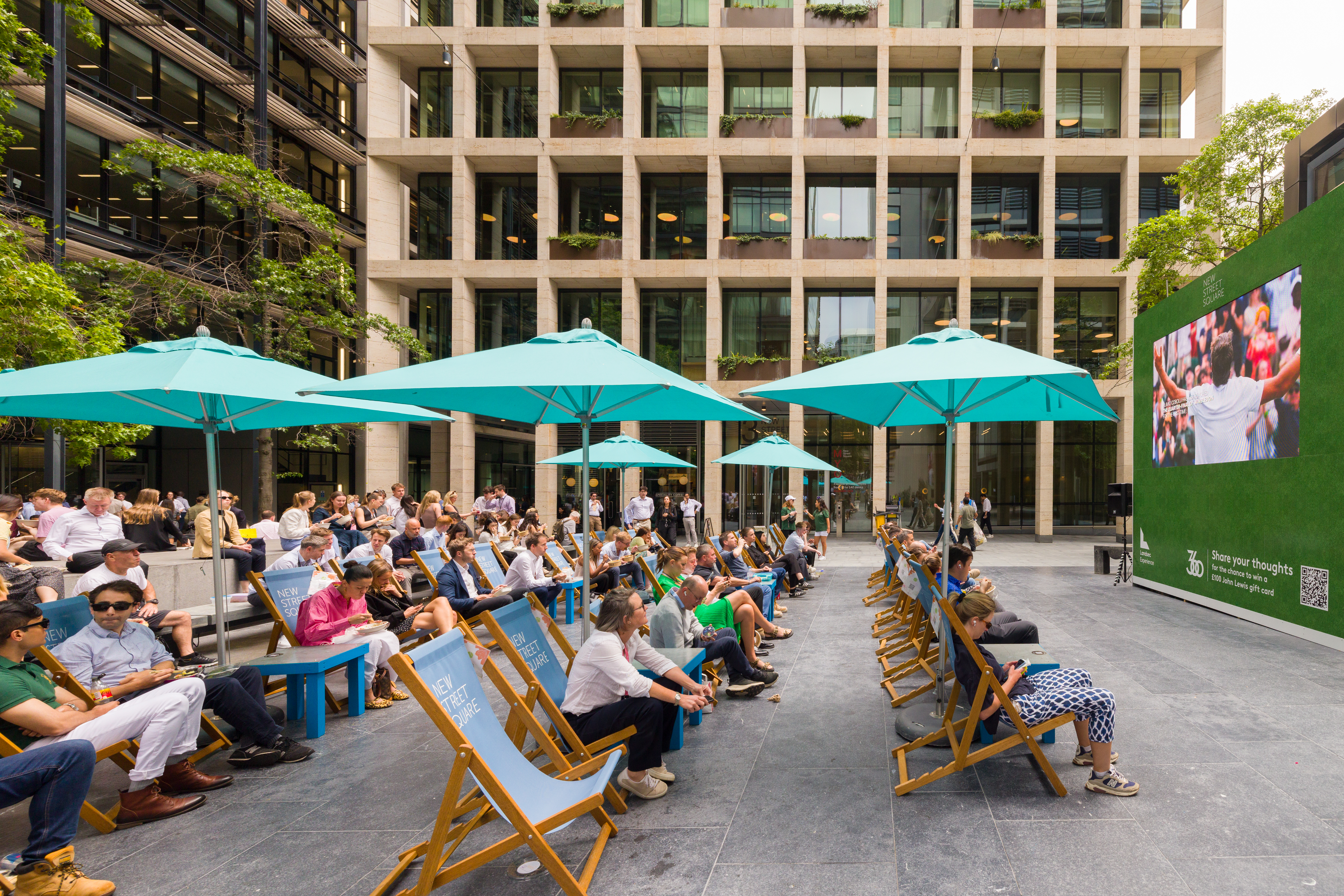 People in deckchairs at New Street Square watching tennis on the big screen