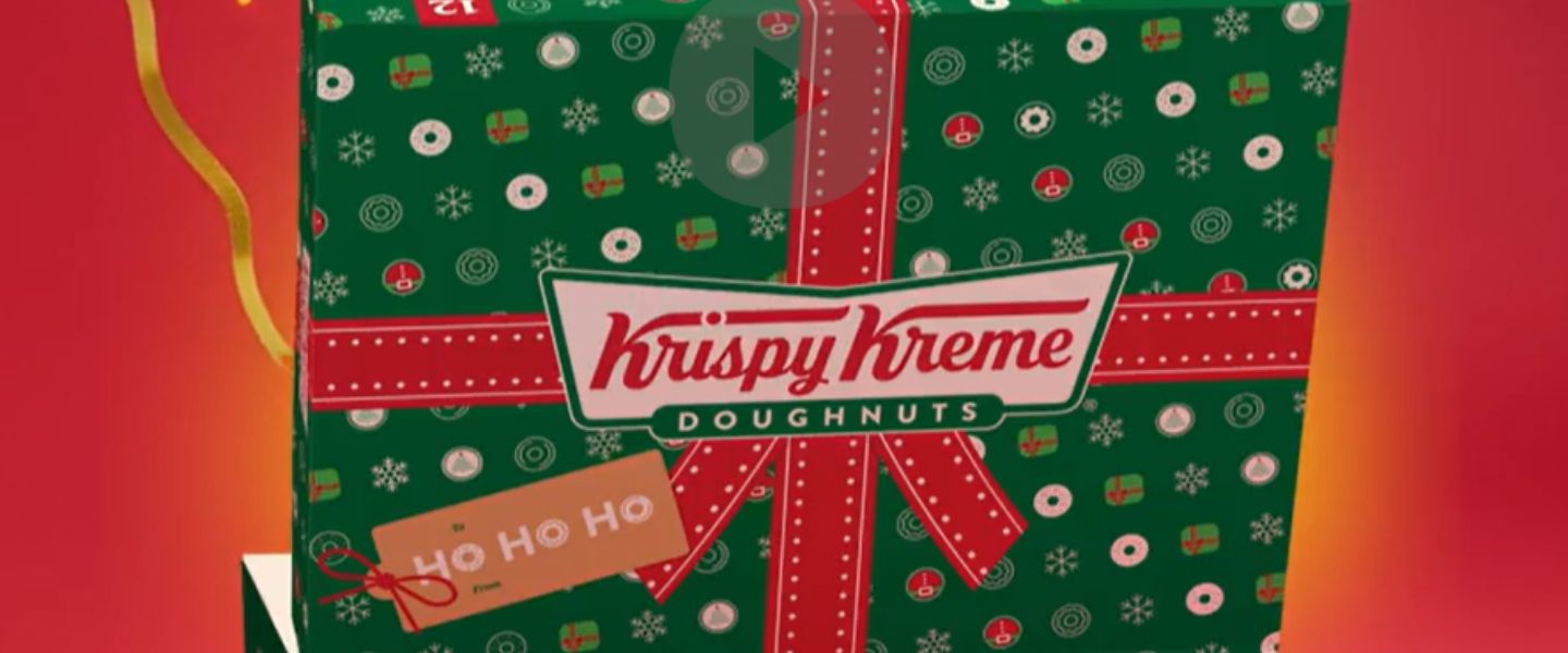 A Krispy Kreme Christmas box, green with a red ribbon on it