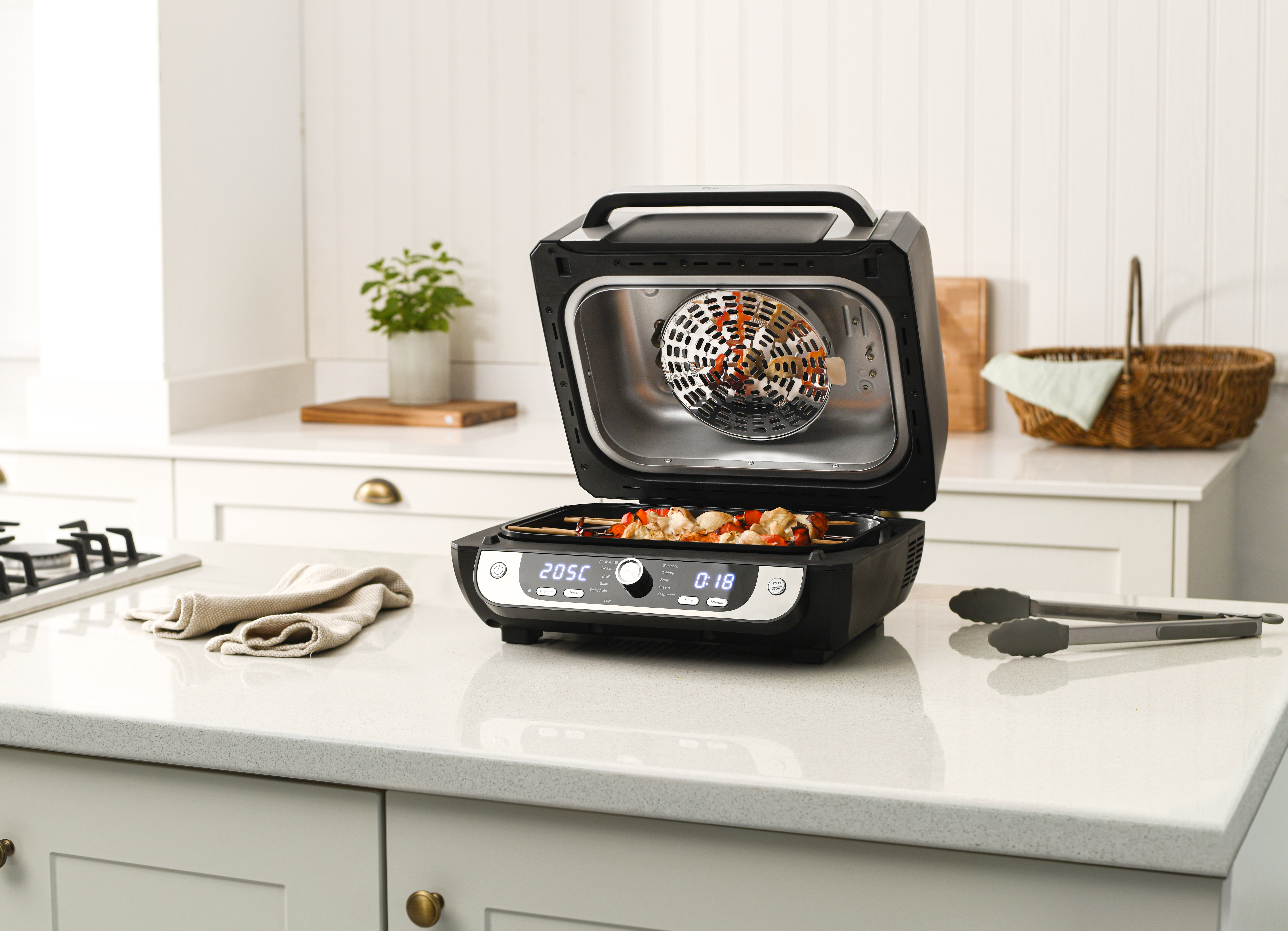 A black air fryer grill on a white counter top