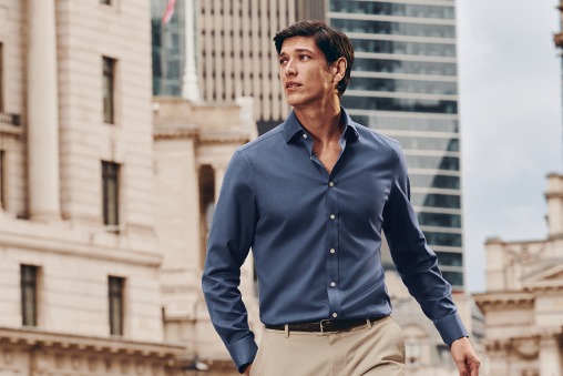 A man wearing a blue shirt outside in a city