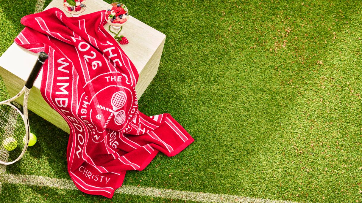 A Christy Wimbledon Championship towel on a tennis court with summery drinks