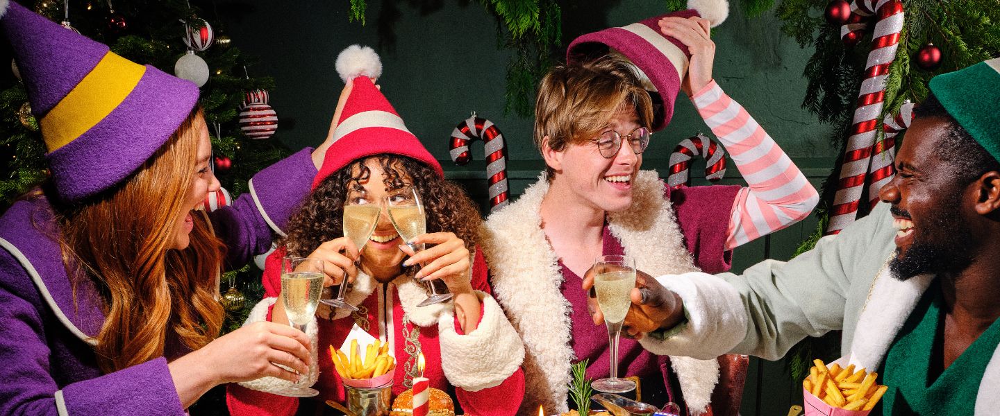 Four people dressed in elf outfits around a dinner table
