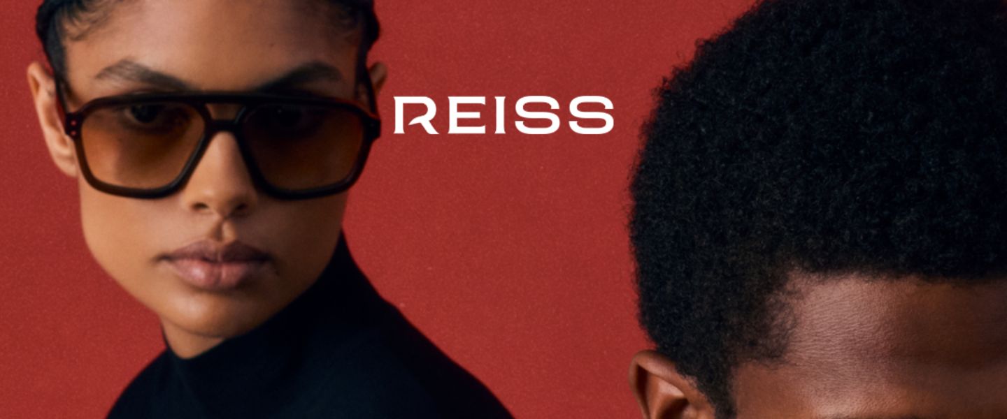 A woman wearing sunglasses against a red background with the Reiss logo on top