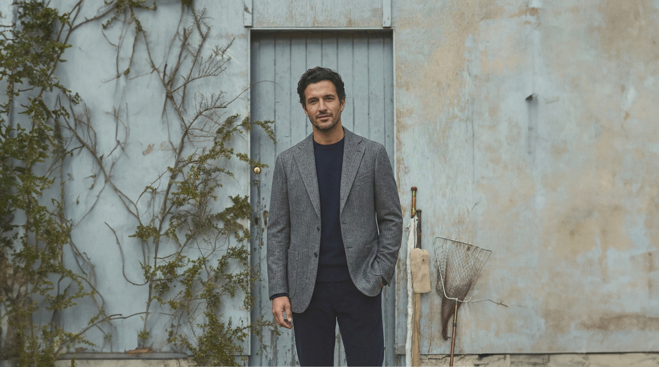 A man wearing a smart jacket and trousers outdoors