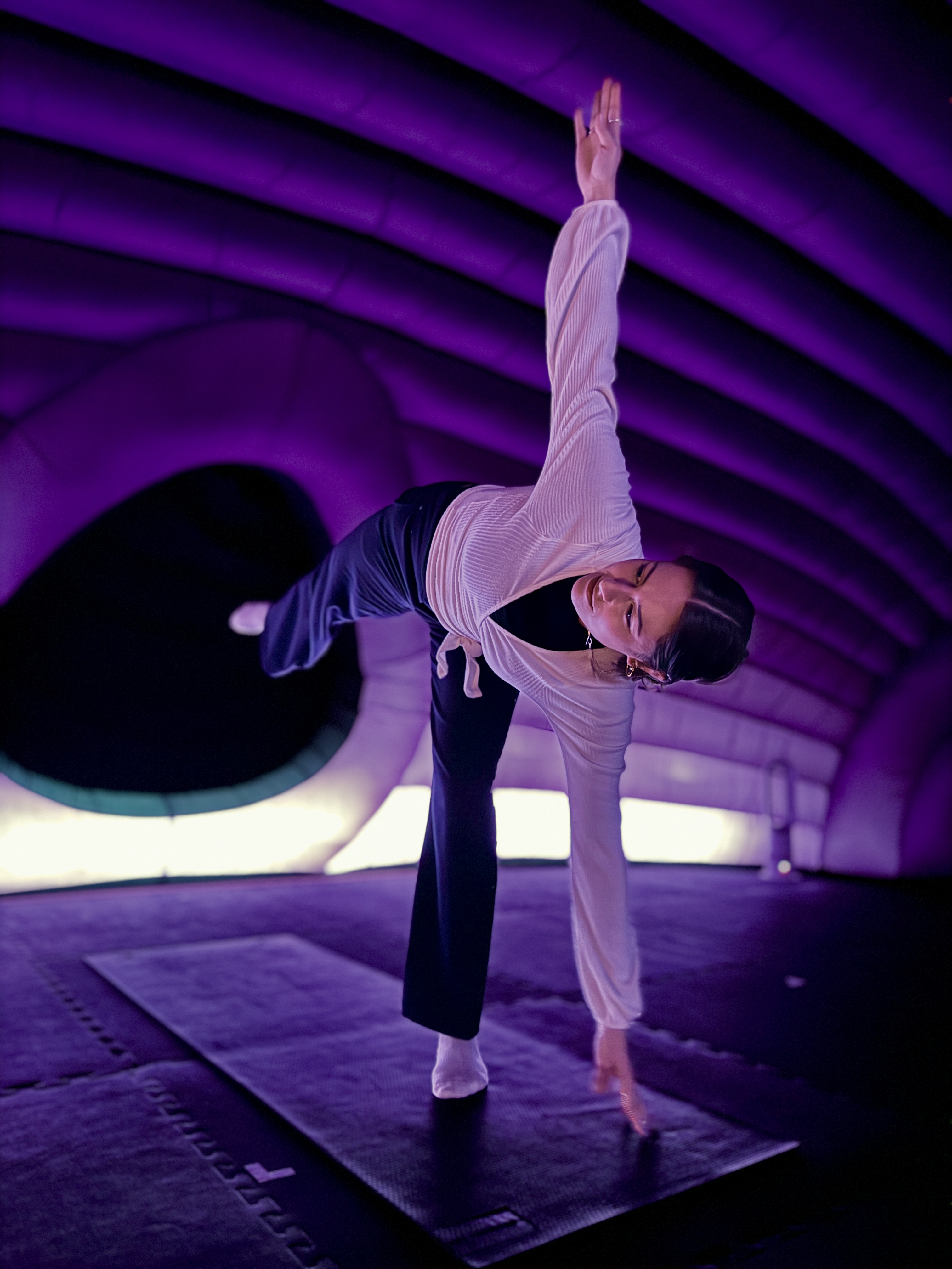 A women in yoga clothes holding a yoga pose.