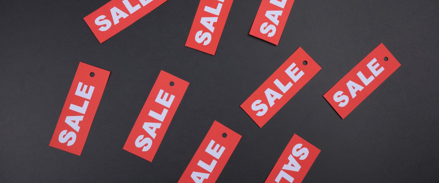 A black background with red SALE labels on top