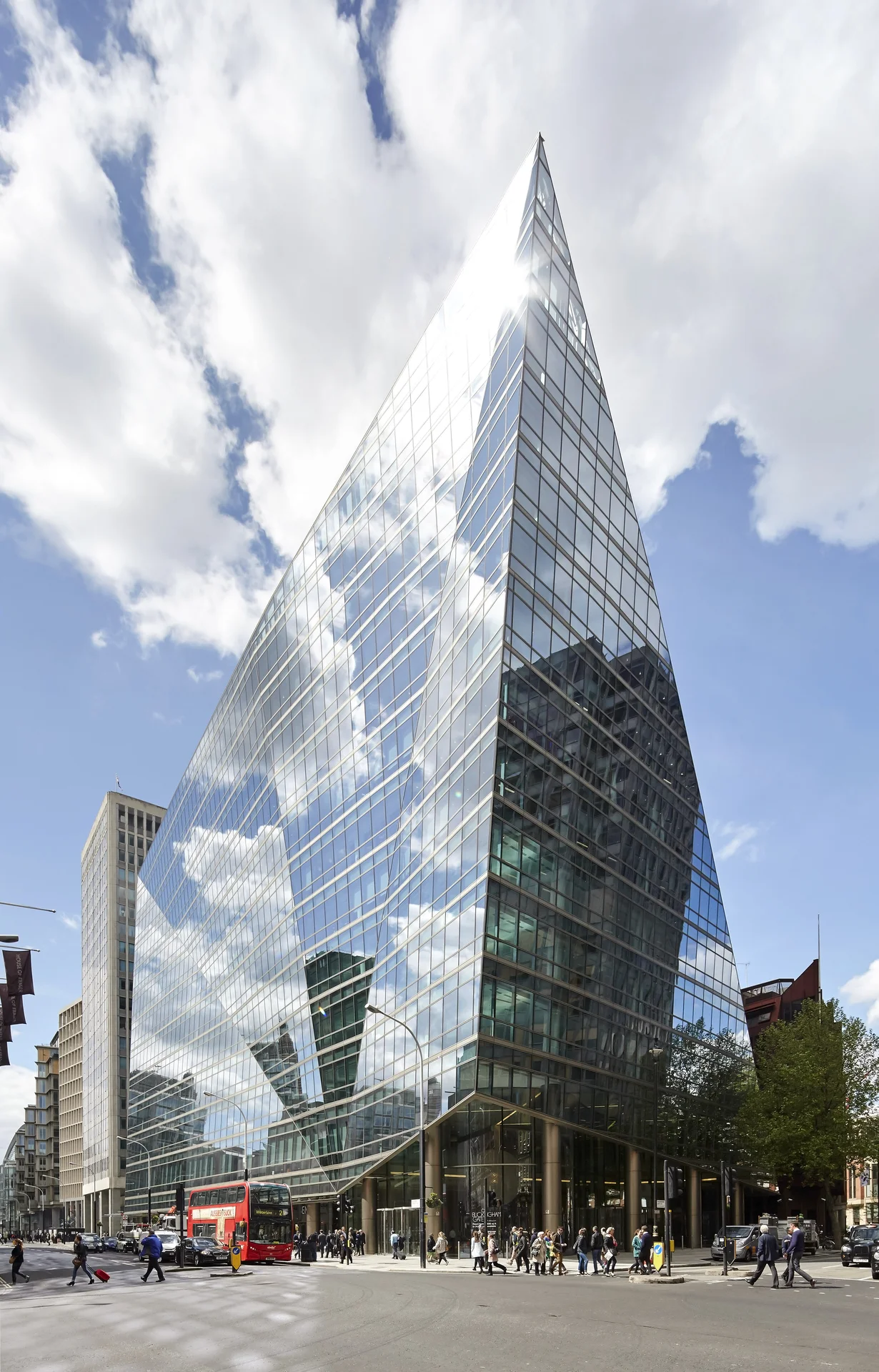 Modern glass office building with sharp, triangular architecture at noon