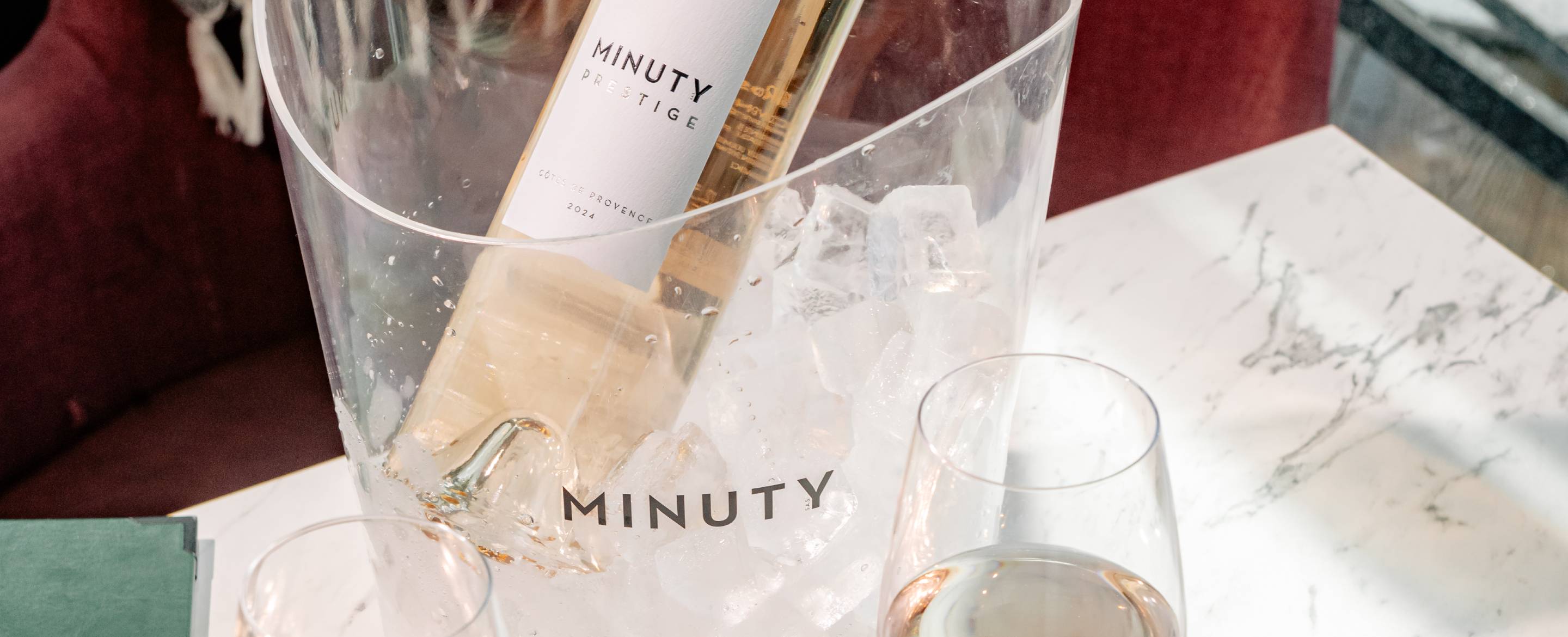 A bottle of Minuty Prestige in a clear Minuty ice bucket