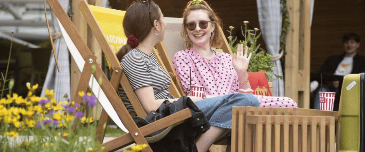 Two people sitting in the sun At Victoria London