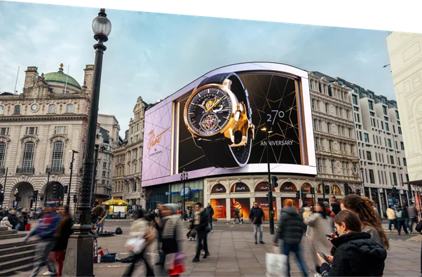 A bustling urban square with a large digital billboard displaying a luxury watch, surrounded by historic buildings and pedestrians.