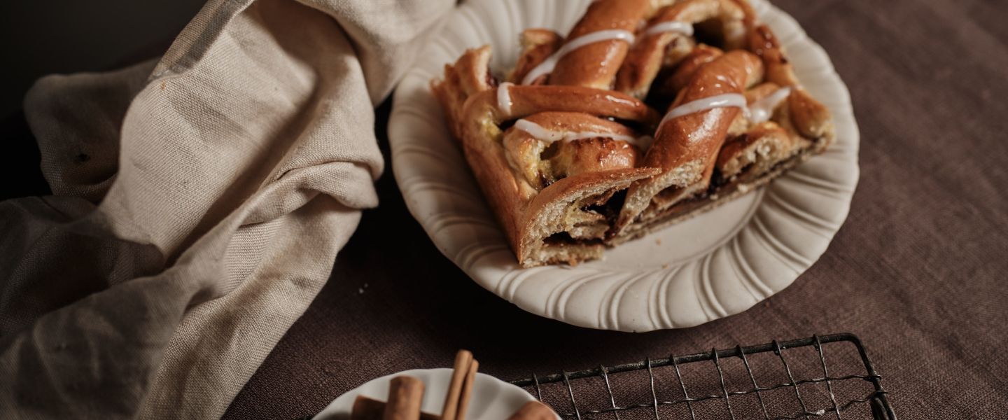 A cinnamon social slice from Ole & Steen on a wooden table with fabric next to it