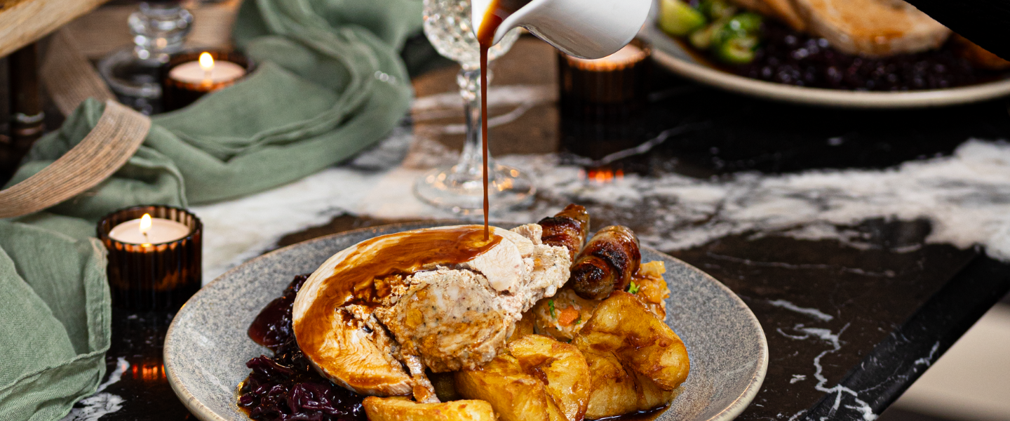 Pouring gravy over a Christmas dinner