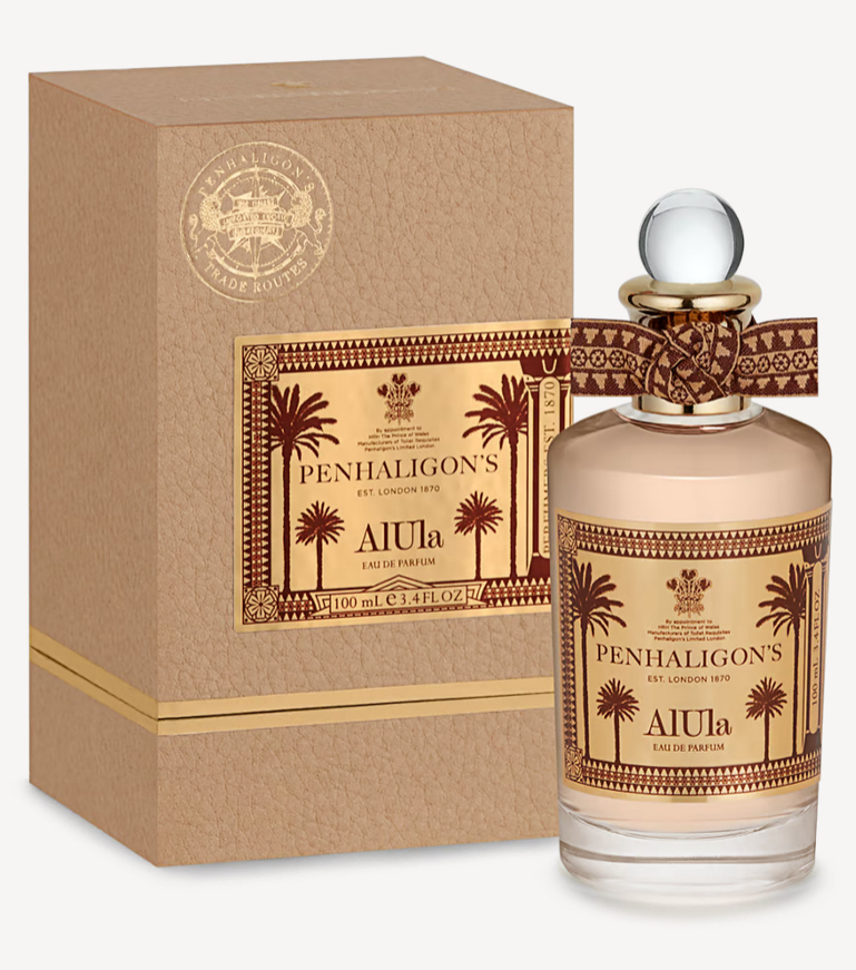 A fancy bottle of perfume stood beside the box a glass lid with a ribbon and images of palm trees