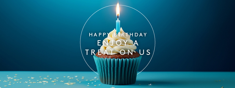 A cupcake with a lit candle and a text overlay that reads 'Happy Birthday: Enjoy a treat on us'