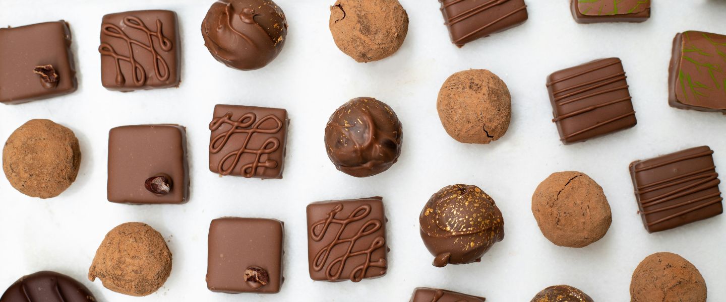 A white table with rows of chocolates