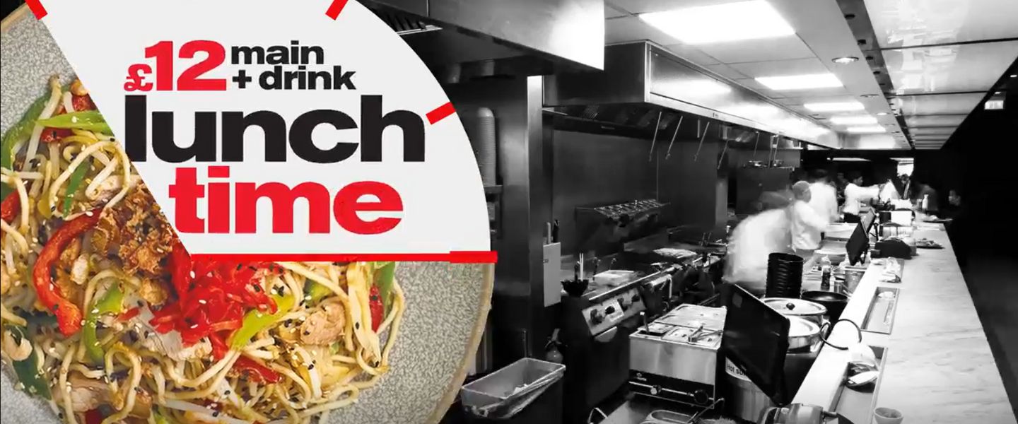 A clock over a plate saying "£12 main and drink lunch time" overlaid on top of a black and white image of a Wagamama kitchen