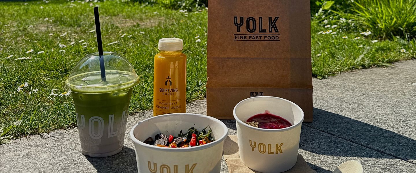 An iced drink, bottle of juice and bowls of food from Yolk