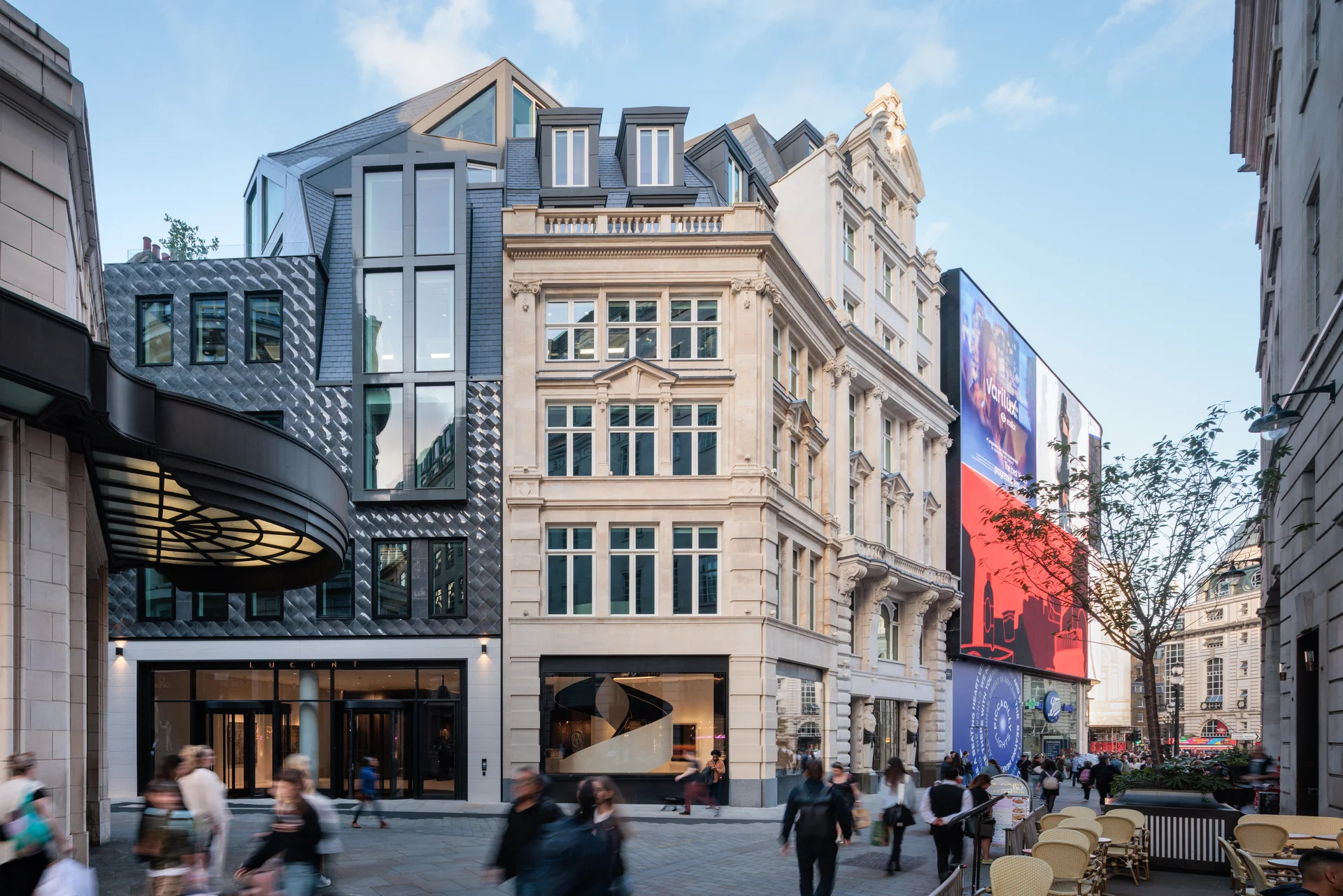 Lucent building with modern architecture and busy Piccadilly street at dusk