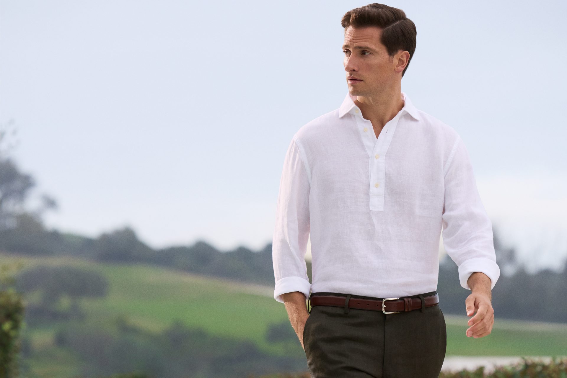 A man in a white shirt walking outside