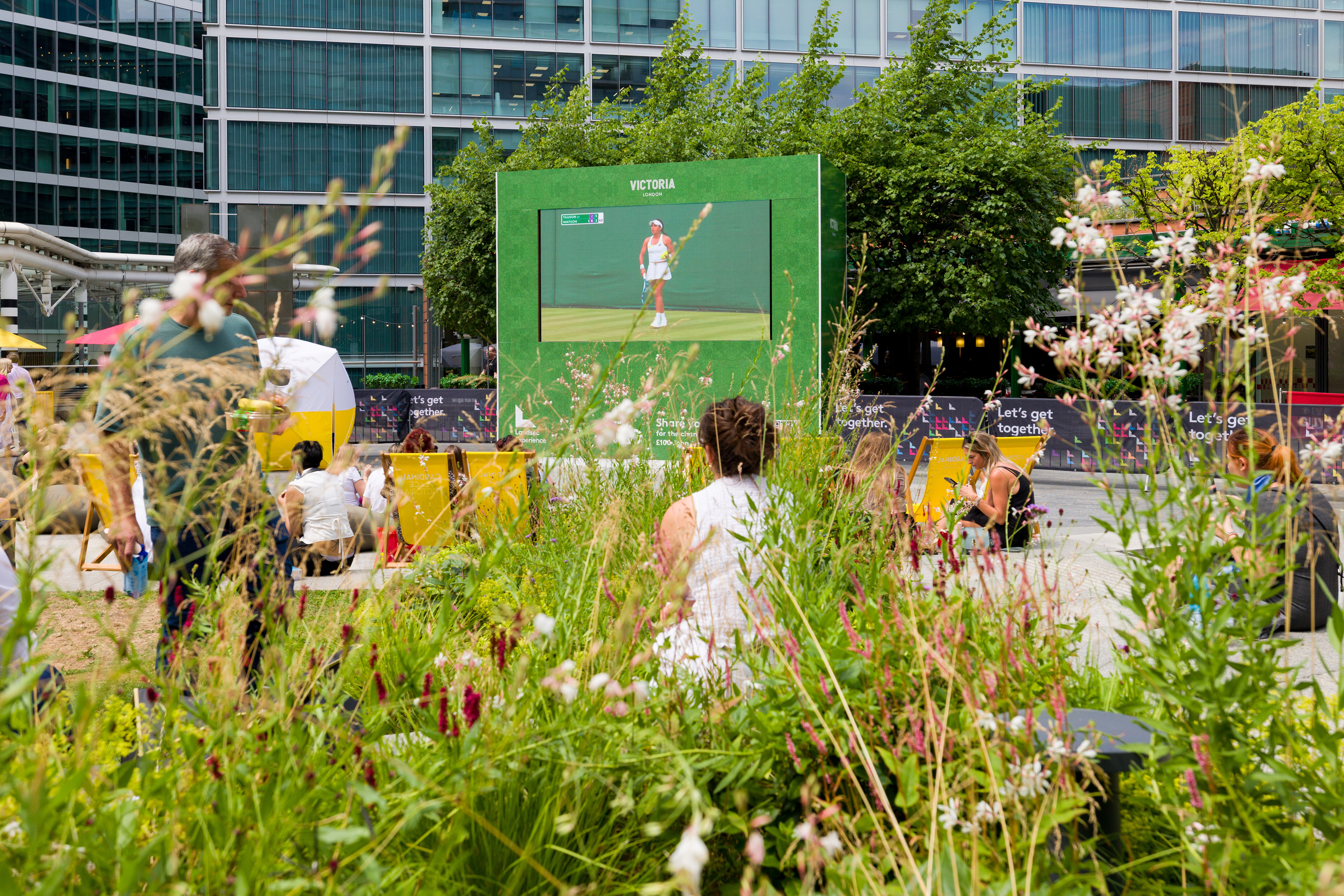 People in the garden at Victoria watching tennis on the big screen