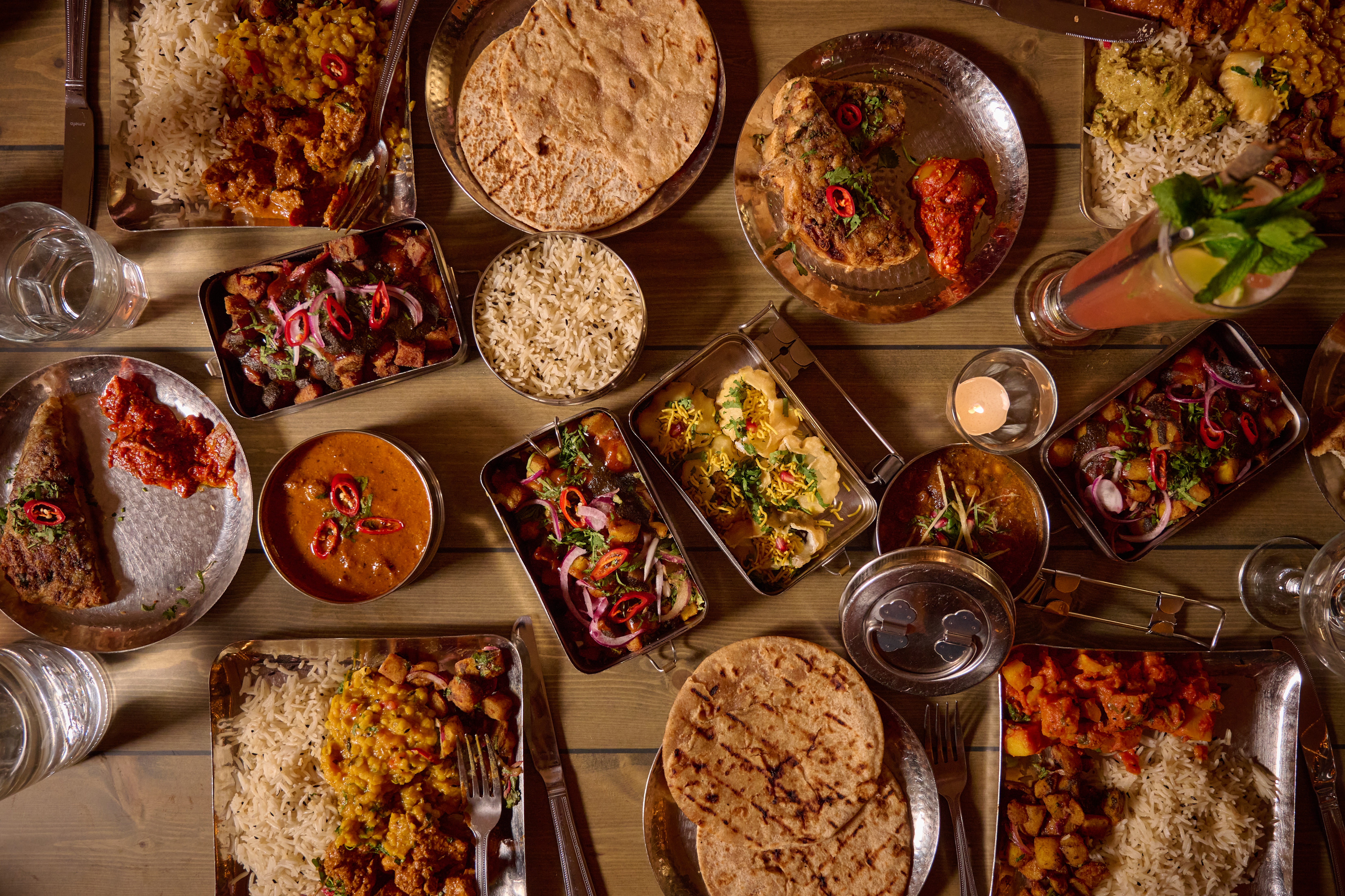 A festive dinner table filled with Indian cuisine 