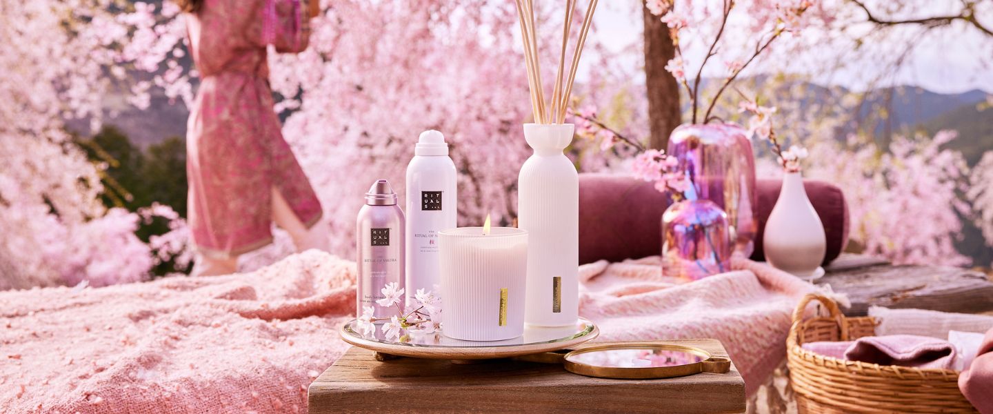 Rituals of Sakura range products on a tray in front of pink blossom trees