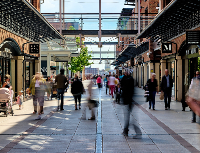 An image of people walking around the mall at Gunwharf Quays with shops in the background