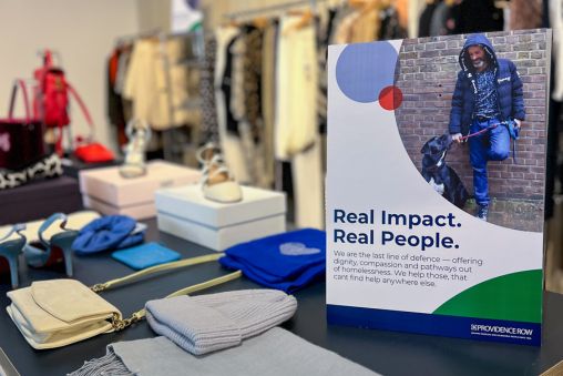 Round Retail in One New Change. A table of knitted clothes next to a sign saying "Real Impact. Real People."