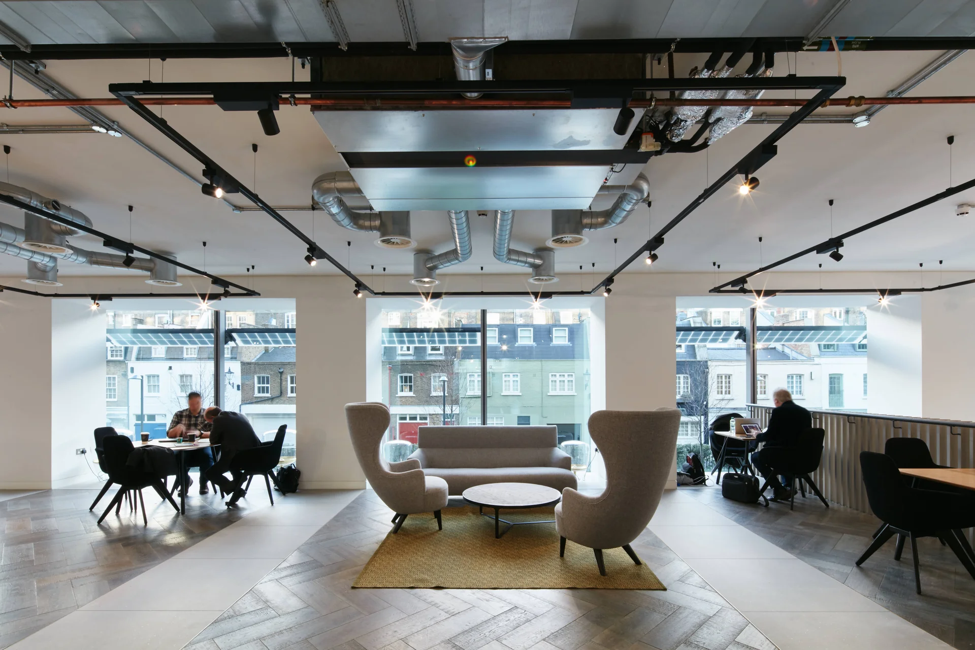 Modern office reception area with lounge chairs and large windows