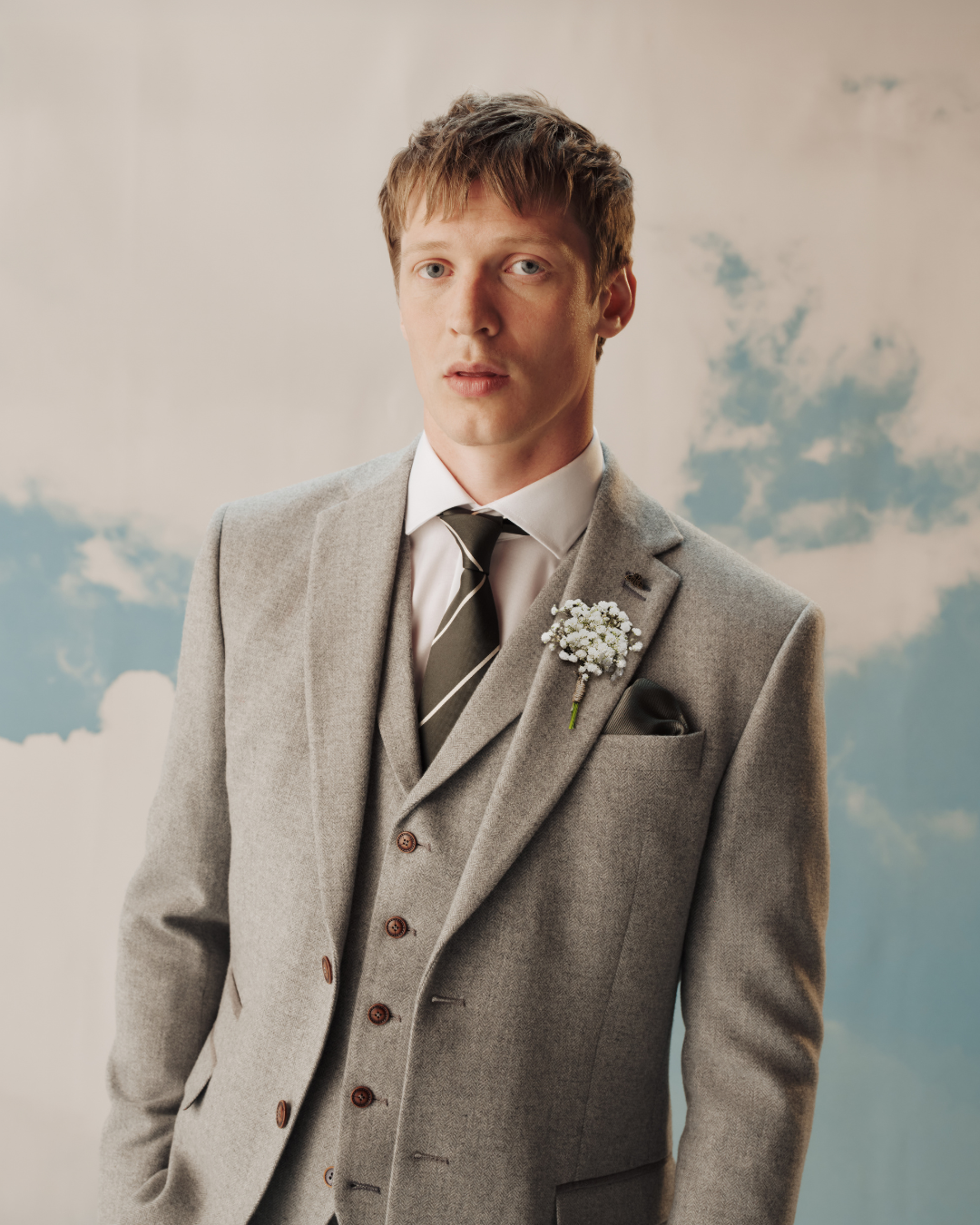 A model wearing a light grey three-piece suit