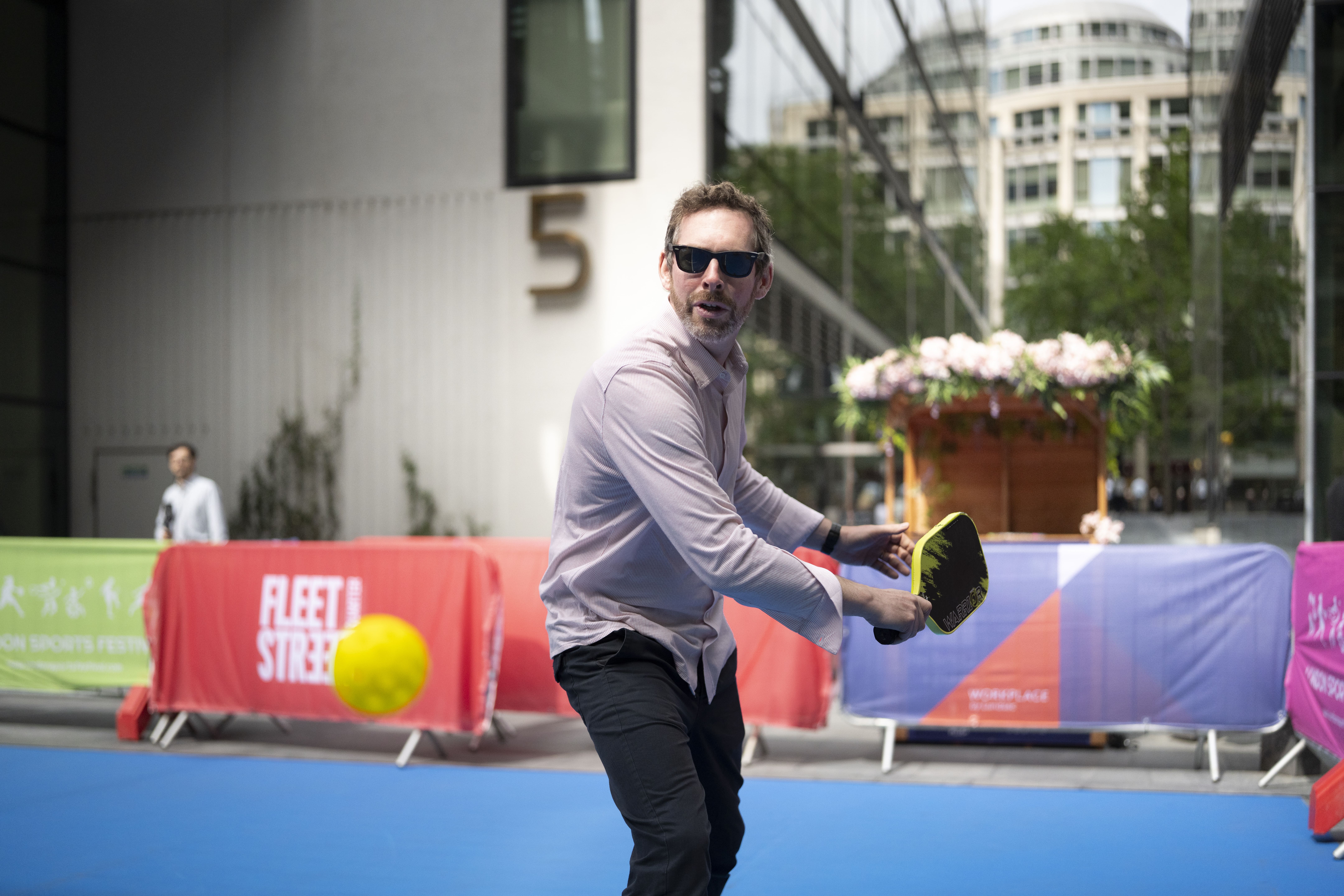 person holding pickleball bat and ball