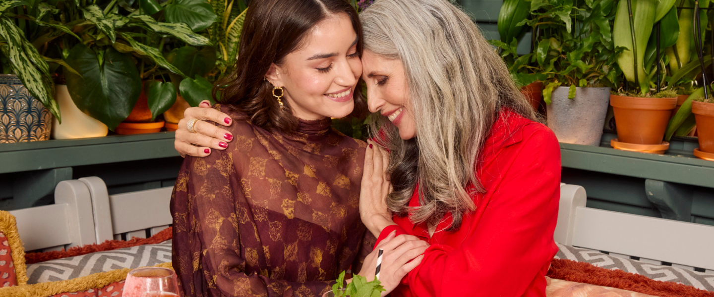 Two women hugging at table