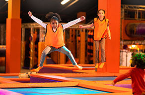 Child in orange high vis on trampoline