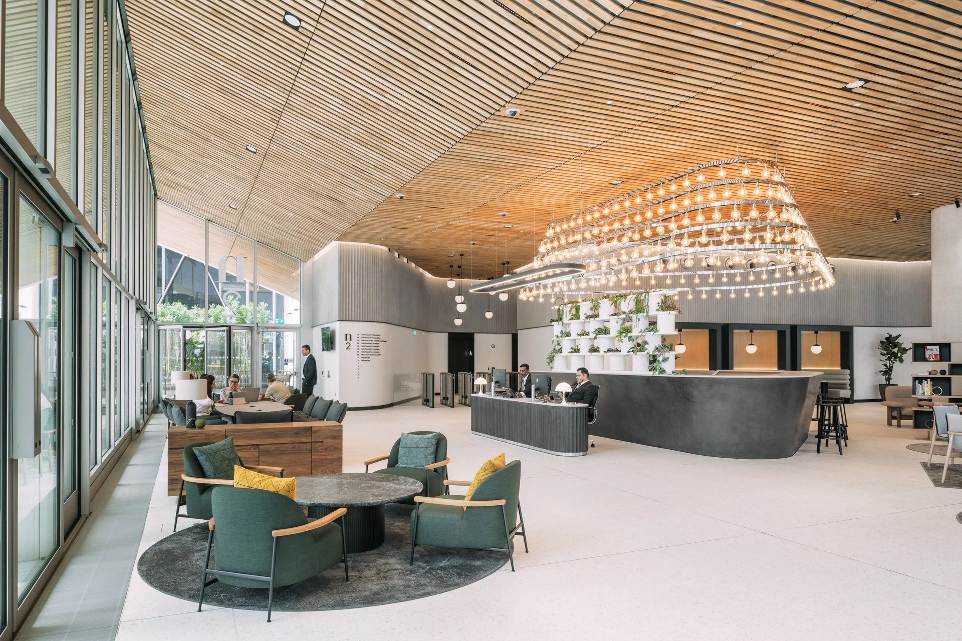 Spacious reception area with wood ceiling, modern chandelier, and green seating