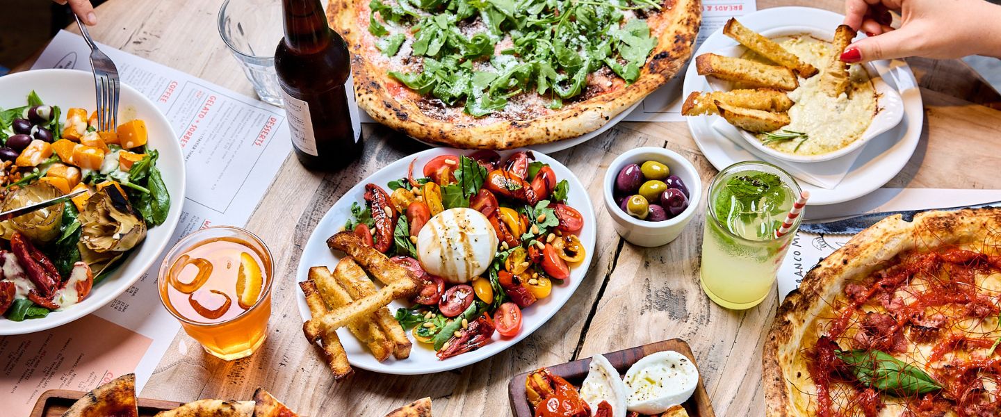 A table of pizzas and sides