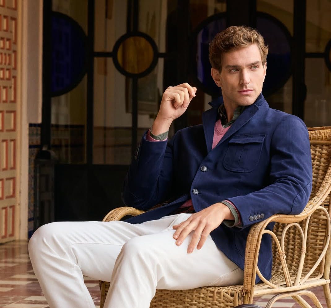 A man in a blue shirt sitting in a wicker chair