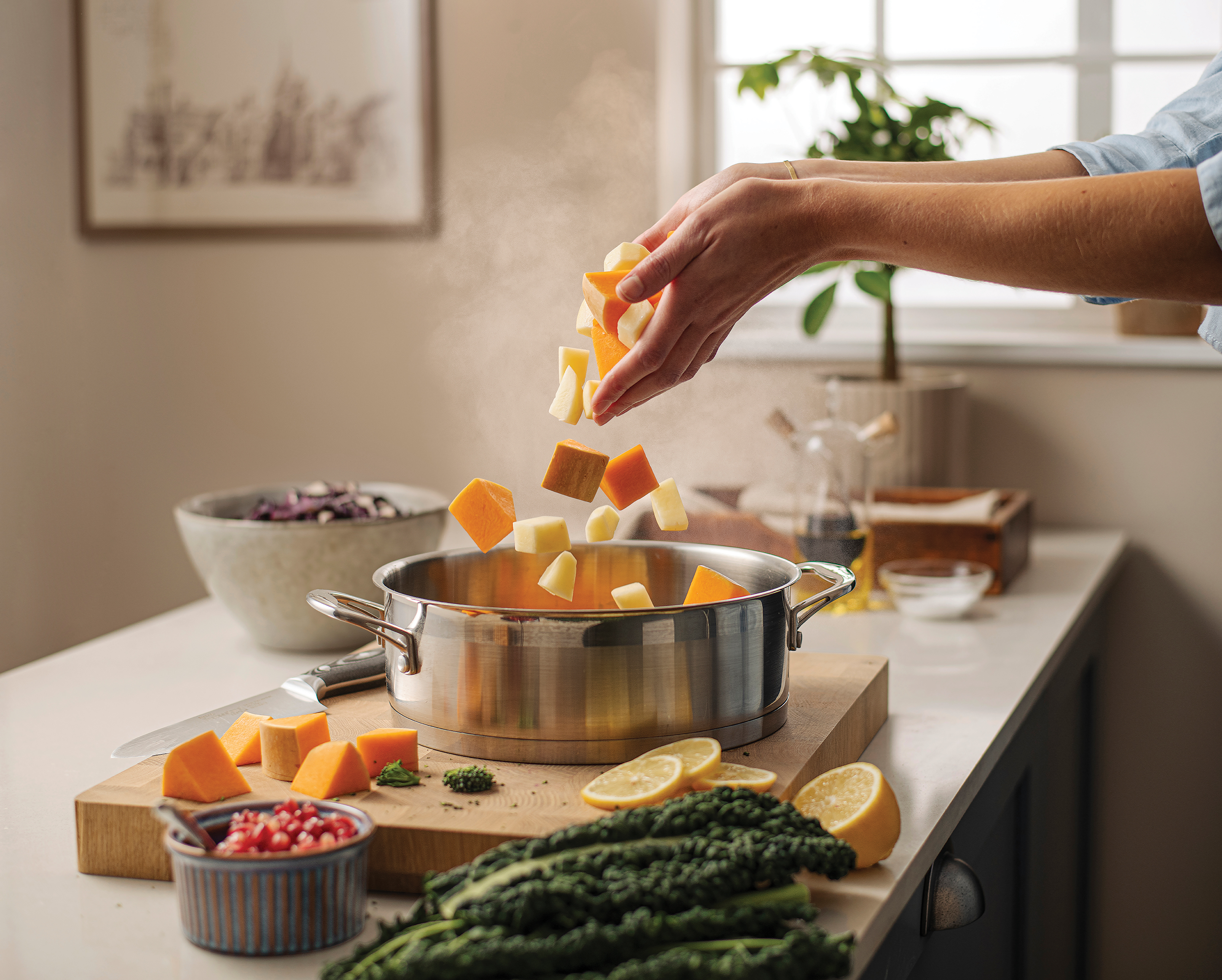 A woman tosses chopped vegetables into a pot