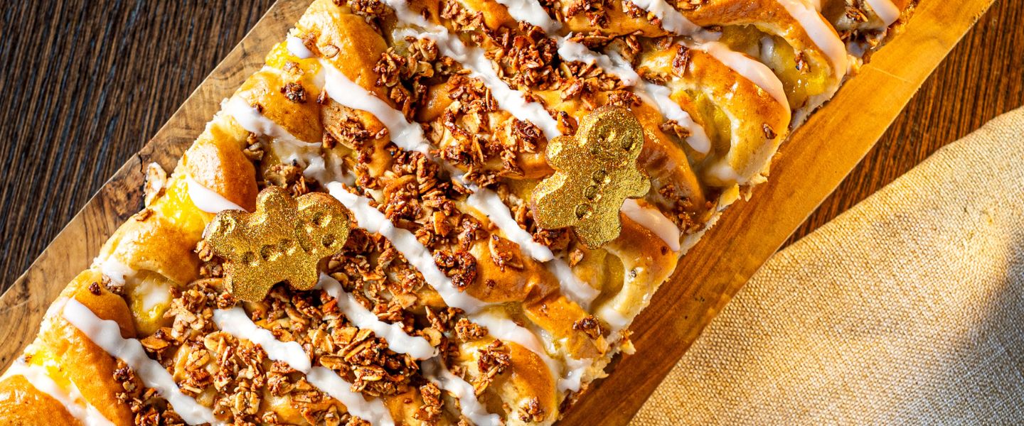 A close up image of the Gingerbread Social from Ole & Steen, showing a pastry with icing and mini gingerbread men on top