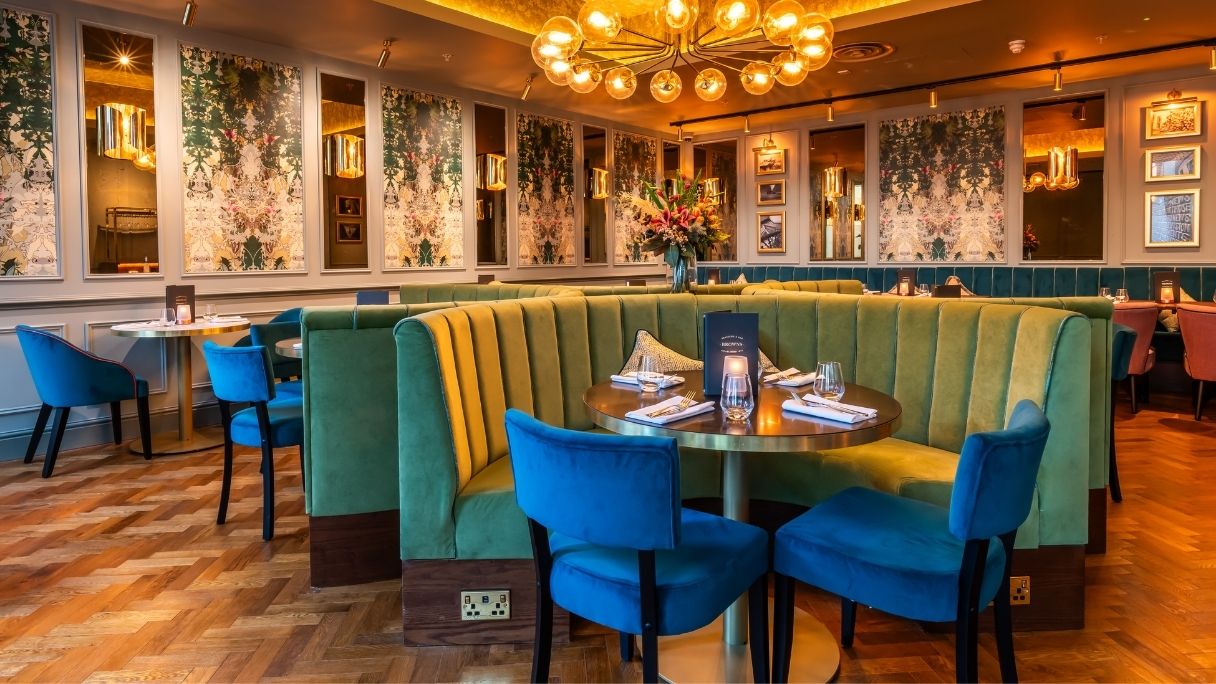 A round booth at Browns with teal couches and dark blue chairs