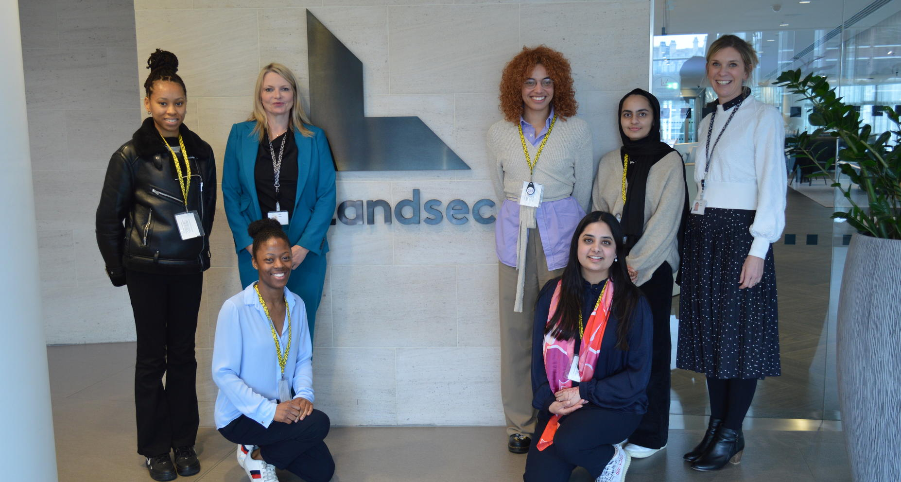 Group of seven women in business attire posing in front of a Landsec logo wall.