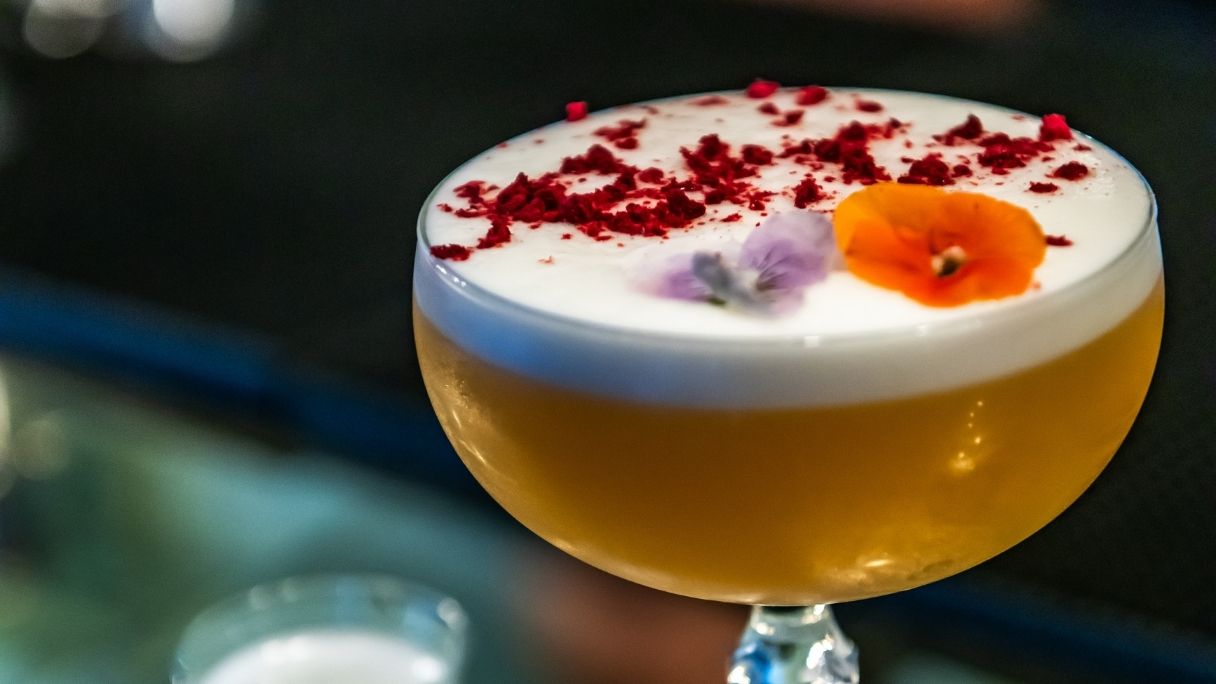 A cocktail from Browns with edible flowers sitting in the foam