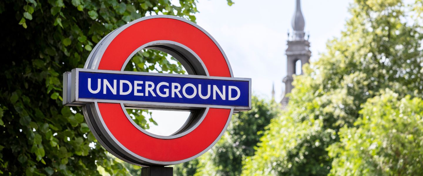 London Underground sign with green trees in the background