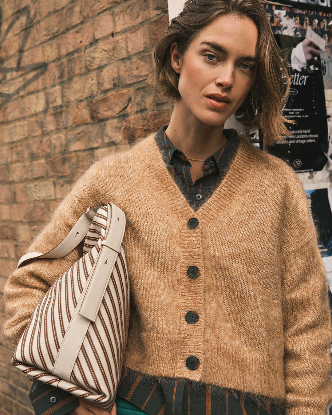 A female model with a light striped bag from Radley London