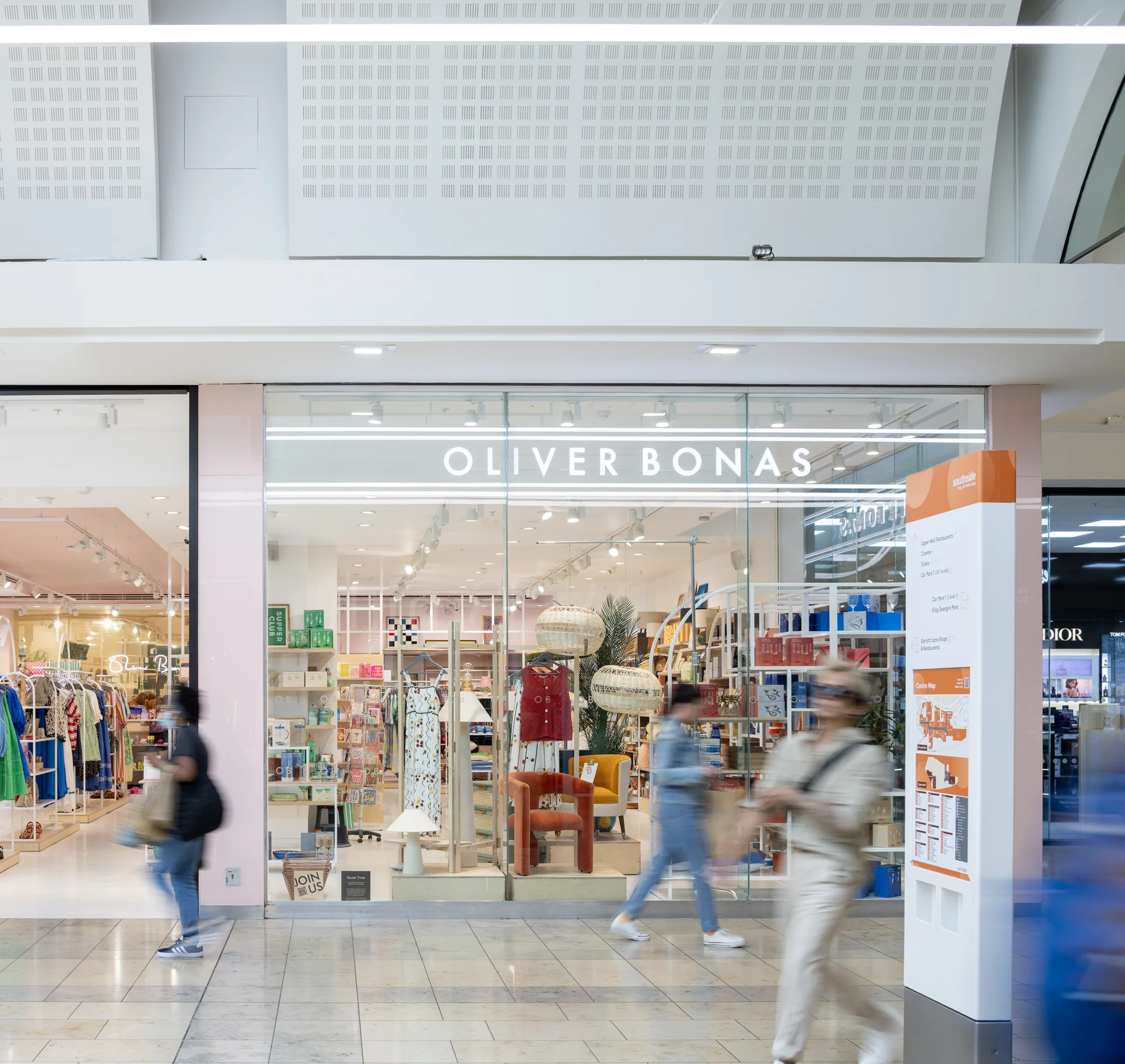 Interior view of **Southside Shopping Centre** in Wandsworth, highlighting the storefront of the **Oliver Bonas** retail store with its distinctive light pink facade, with shoppers walking past.